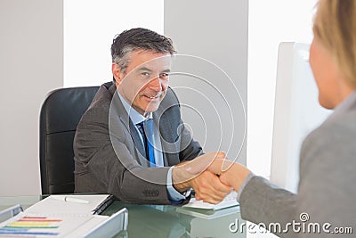 Cheerful businessman shaking the hand of a interviewee Stock Photo