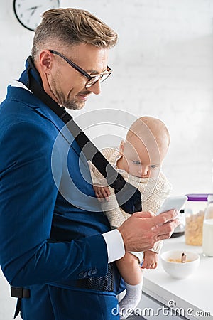 cheerful businessman smartphone and infant daughter Stock Photo