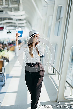 Cheerful businesswoman waiting for her flight at airport. Young woman at the airport. Woman is waiting flight in waiting Stock Photo