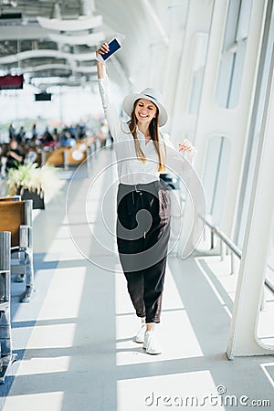 Cheerful businesswoman waiting for her flight at airport. Young woman at the airport. A young woman is waiting her Stock Photo