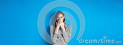 Cheerful caucasina girl in dress laughing and having fun, covering mouth with hands and chuckle over something funny Stock Photo
