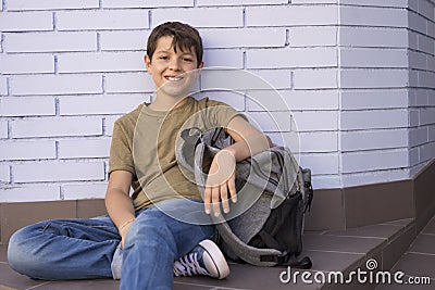 Cheerful child carrying his backpack Stock Photo