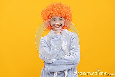 cheerful child in fancy orange wig hair wear home bathrobe, morning Stock Photo