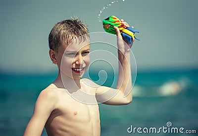 Cheerful child in swimware playing in sea with toy Stock Photo