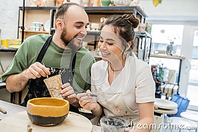 Cheerful couple of artisans holding paintbrushes Stock Photo