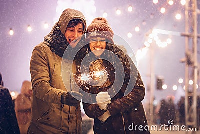 Cheerful Couple Holding Bengal Lights Standing In Night City Stock Photo