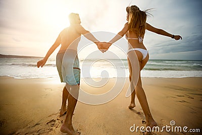 Cheerful couple in love run on the beach Stock Photo