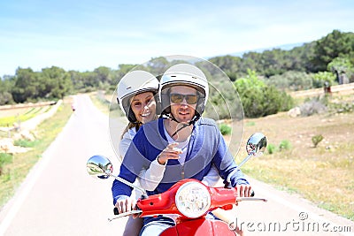 Cheerful couple on red moto visiting island Stock Photo