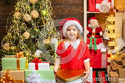 Cheerful cute child opening a Christmas present. Happy child decorating Christmas tree. Cute little child near Christmas Stock Photo