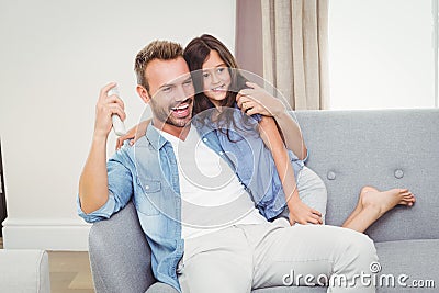 Cheerful daughter and father watching television Stock Photo