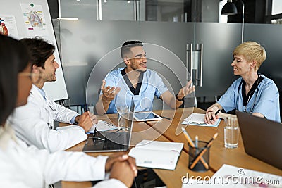 Cheerful doctors multiracial team having breefing, discussing cases Stock Photo
