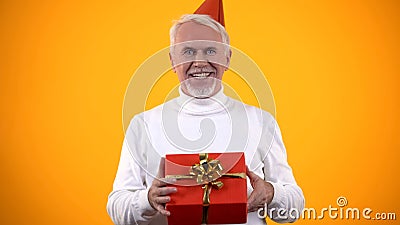 Cheerful elderly man holding gift box, present from close people, happiness Stock Photo