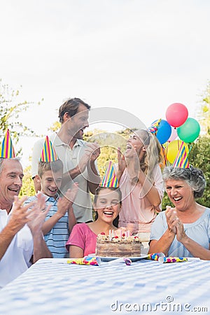 Cheerful extended family clapping for little girls birthday Stock Photo