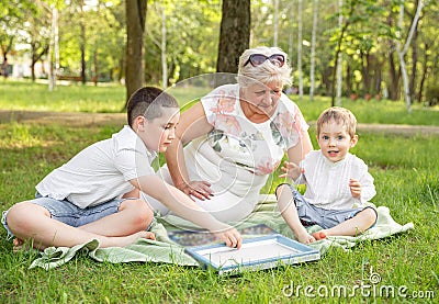 Cheerful extended family playing board game in their backyard. Stock Photo