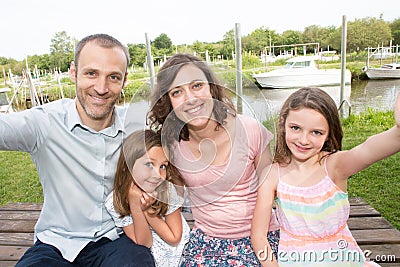 Family of four make selfie outdoor father mother and daughter sister Stock Photo