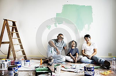 Cheerful family painting house wall Stock Photo