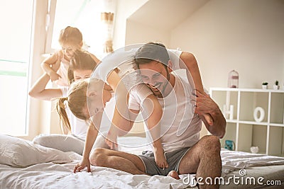 Cheerful family playing together on bed. Stock Photo