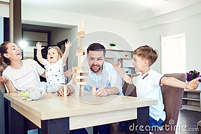 A family plays board games sitting at a table indoors. Stock Photo