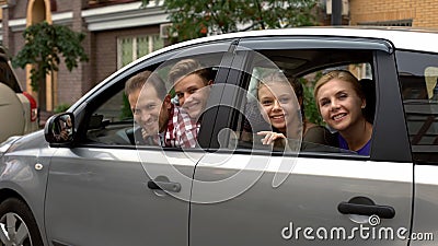 Cheerful family sitting in car and smiling into camera, auto rental, insurance Stock Photo