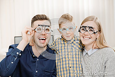 Cheerful family with small child reception doctor ophthalmologist using glasses Stock Photo