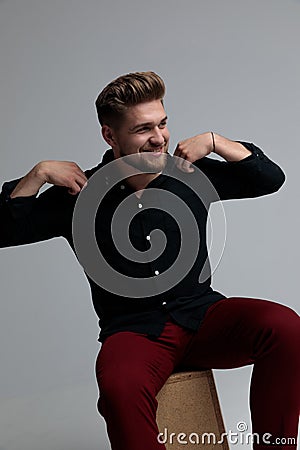 Cheerful fashion man adjusting his shirt and looking away Stock Photo