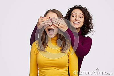 Cheerful female making surprise for best friend Stock Photo