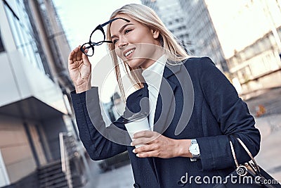 Cheerful female manager getting to work by foot drinking morning Stock Photo