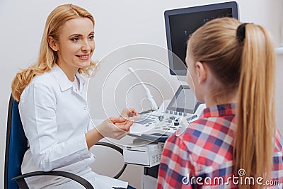 Cheerful female practitioner consulting young patient in the clinic Stock Photo