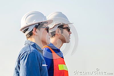 Cheerful female shipping company workers working at the harbor, Engineering man looking to the sky Stock Photo