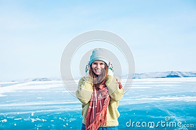 Cheerful female in stylish hat and mittens looking in camera while standing outdoors Stock Photo