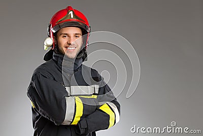 Cheerful firefighter with crossed arms. Stock Photo
