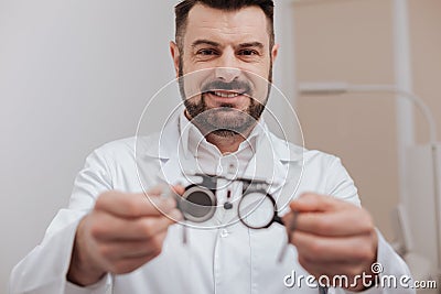Cheerful friendly ophthalmologist holding eye test glasses Stock Photo