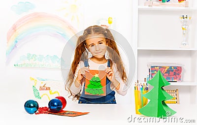 Cheerful girl holds orange card with Xmas tree Stock Photo