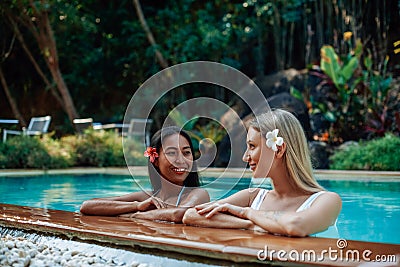 Cheerful girls in bikini swim in pool and enjoy journay in Thailand Stock Photo