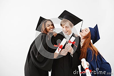 Cheerful graduate classmates celebrating smiling rejoicing over white background. Stock Photo