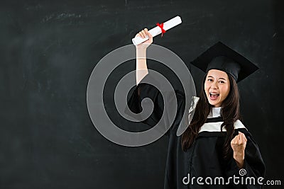 Cheerful graduate gesturing fist Stock Photo