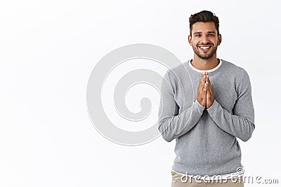 Cheerful and grateful good-looking bearded cute guy in grey sweater appreciate effort, thanking friend for help, hold Stock Photo