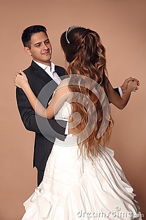 Cheerful Groom and bride dansing wedding dance isolated on beige Stock Photo