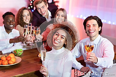 Cheerful Friends Having New Year Dinner Holding Glasses At Home Stock Photo