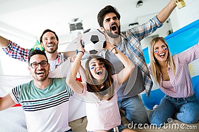 Cheerful group of friends watching football game on tv. Stock Photo