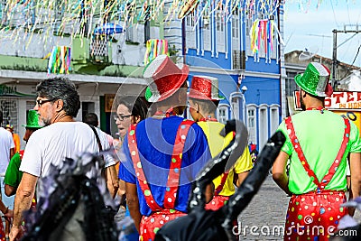 Group of men with clown hats and costumes are walking down the street during a carnival in Salvador Editorial Stock Photo