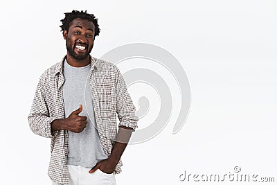 Cheerful, happy carefree attractive african-american man with beard, afro haircut, showing thumb up gesture near stomach Stock Photo