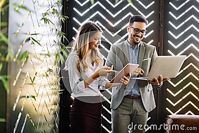Cheerful coworkers in office working and brainstorming together Stock Photo