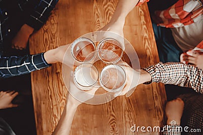 Cheerful and happy old friends are drinking draft beer at pub bar clink glasses. Top view. Friendship concept Stock Photo