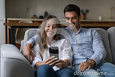 Cheerful happy young couple in love using mobile phone Stock Photo