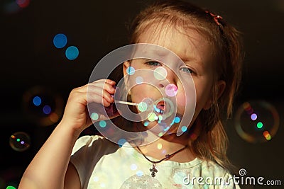 Cheerful inflates soap bubbles Stock Photo