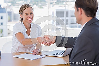 Cheerful interviewer shaking hand of an interviewee Stock Photo