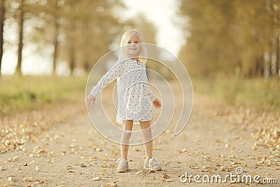 Cheerful little girl at autumn road Stock Photo