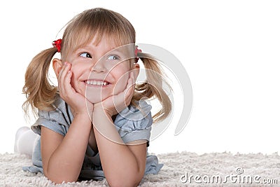 Cheerful little girl lying on the carpet Stock Photo