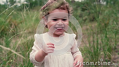 A cheerful little girl is running around in the park. Blond child is walking outdoors. Childhood. stock video footage A cheerful little girl is running around in the park. Blond child is walking outdoors. Childhood. stock video footage